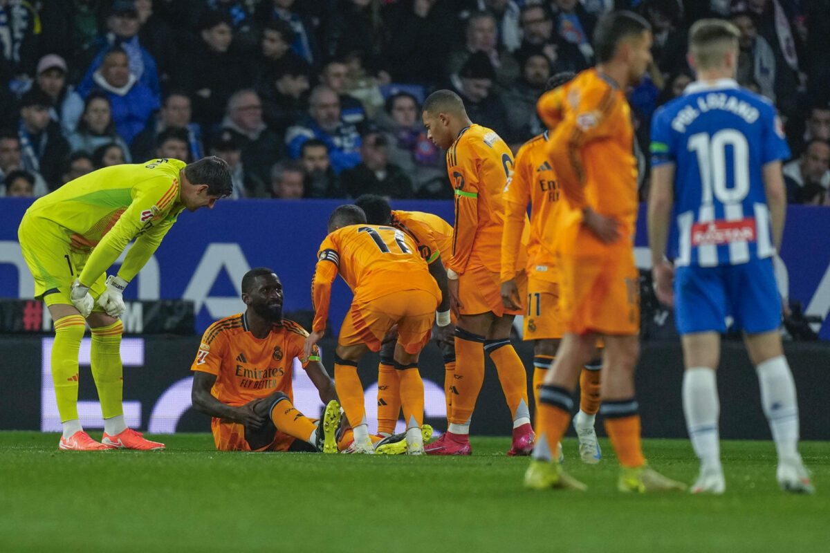 El defensa alemán del Real Madrid Antonio Rudiger (2i) tras caer lesionado durante el encuentro correspondiente a la jornada 22 de Laliga EA Sports entre el Espanyol y Real Madrid en el RCDE Stadium. EFE /Siu Wu